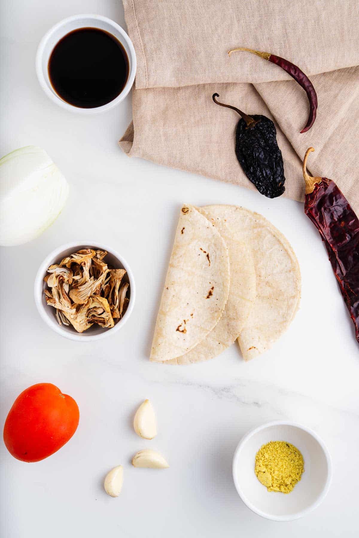 Tamari, Dried Jackfruit, Onion, Tomato, Garlic, Vegetable Stock Powder, Corn Tortillas, and Dried Chiles.