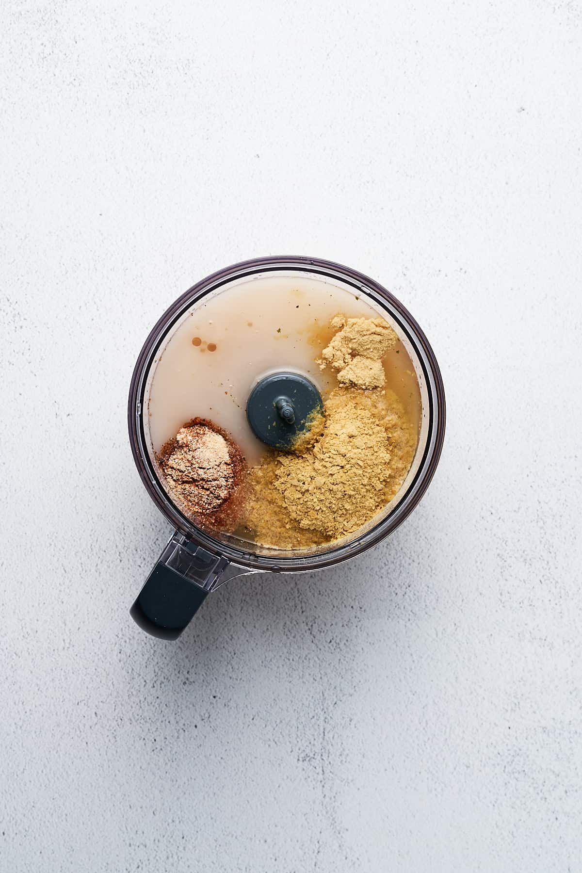 Coconut oil, seasonings, and chickpeas in a food processor.