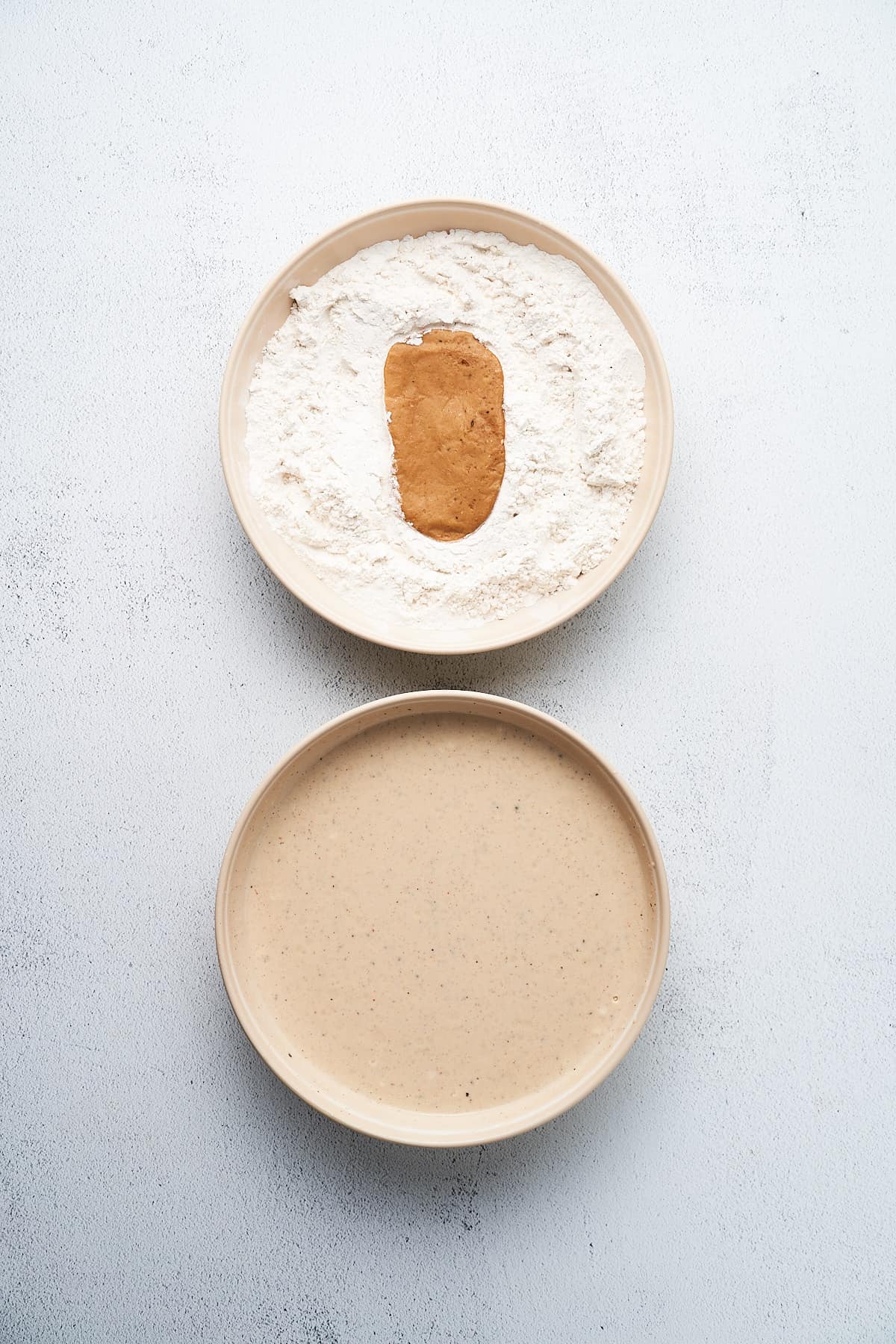 Dredging seitan through flour and batter.