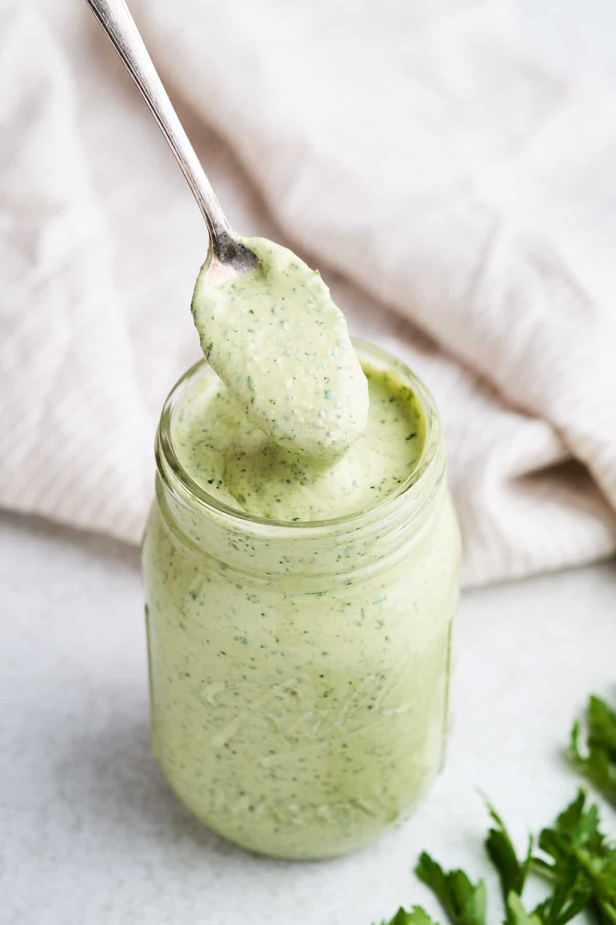 Lemon herb tahini on a spoon.