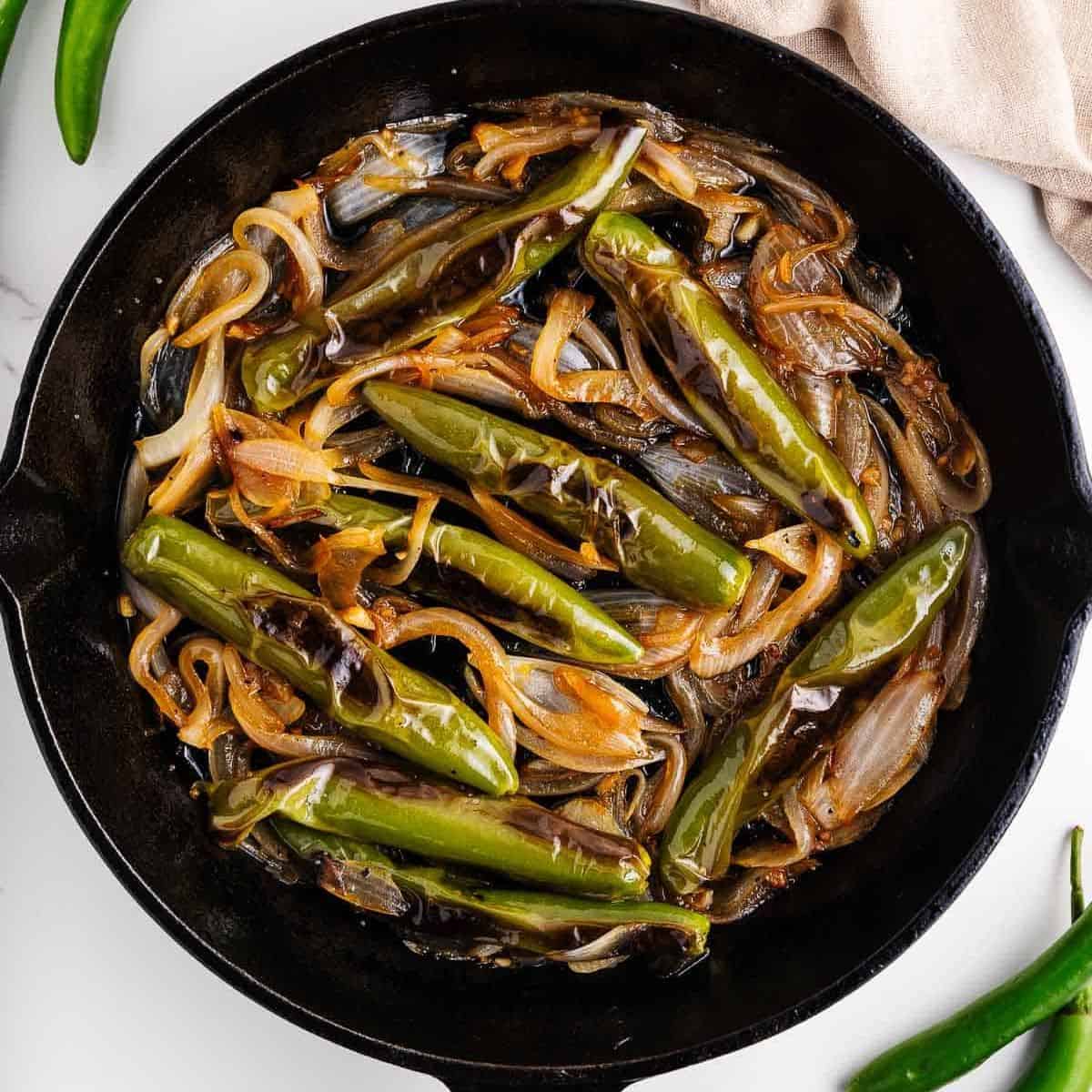 Chiles toreados in a cast iron pan.