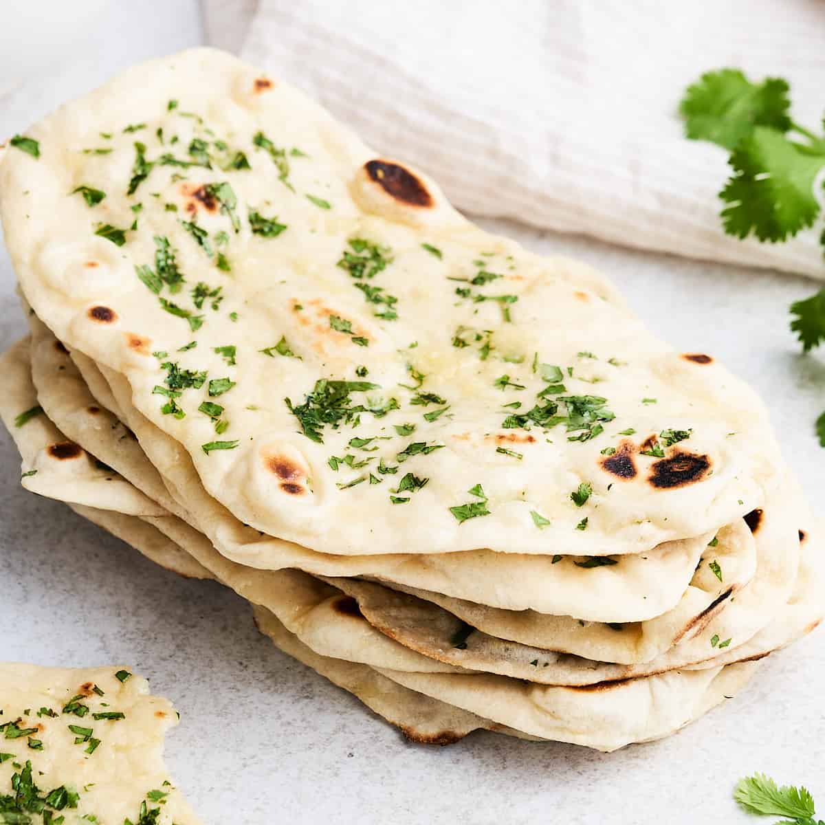 Stacked pieces of vegan naan on a countertop.