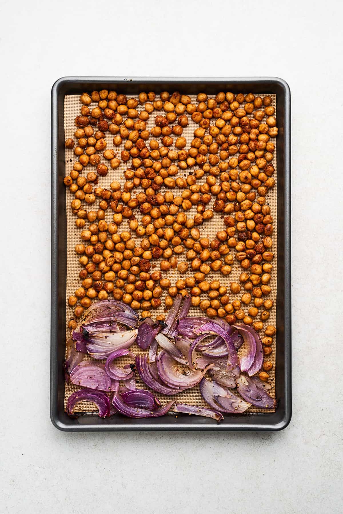 Chickpeas and red onion on a pan.