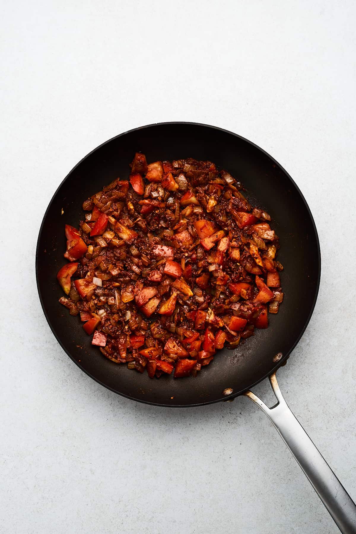 Onions, garlic, tomato, and spices in a pan.