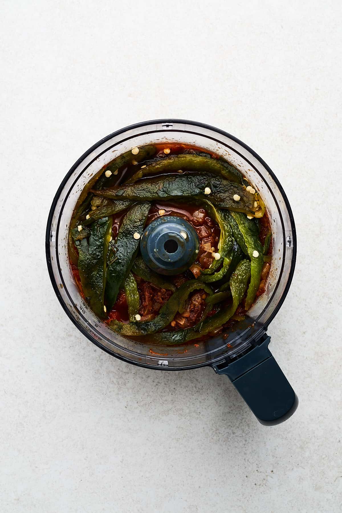 Poblano pepper and other vegetables in a food processor.