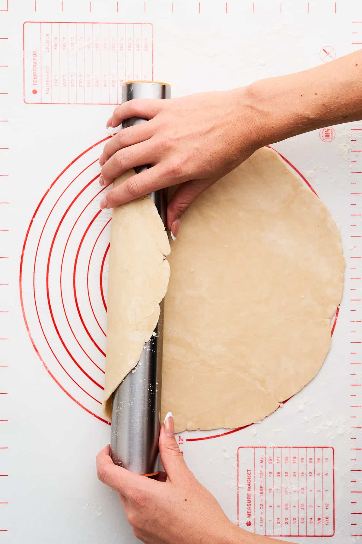 Picking up pie dough on a rolling pin.
