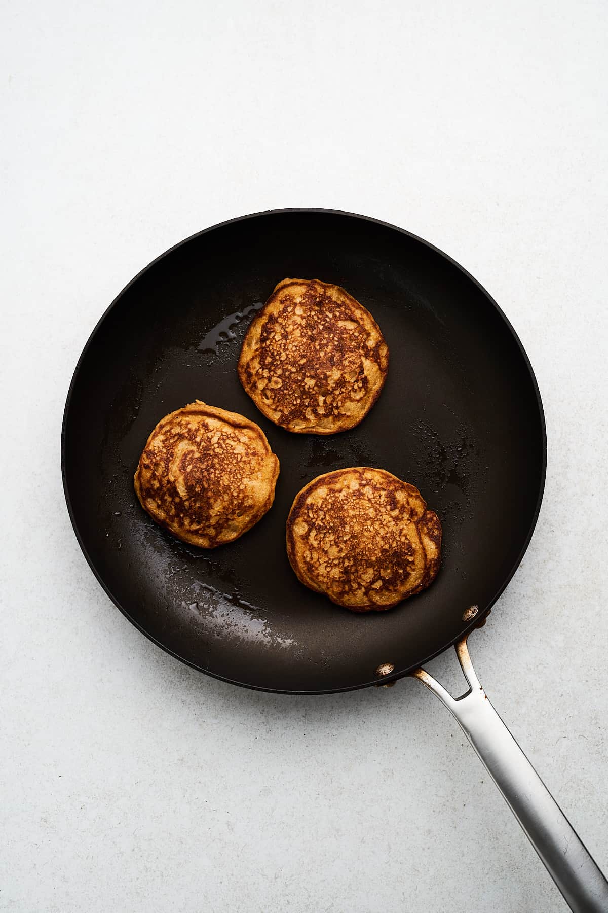 Vegan sweet potato pancakes in a pan.