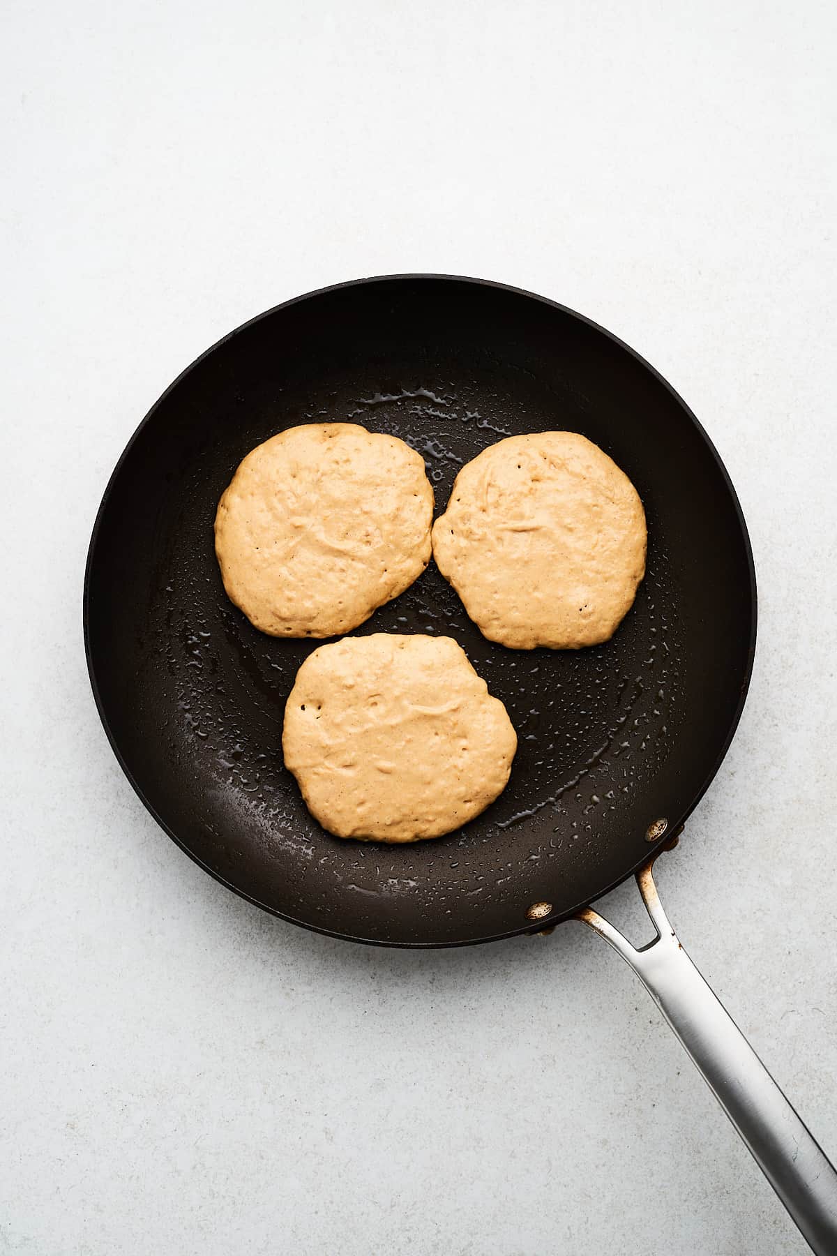 Vegan sweet potato pancakes in a pan.