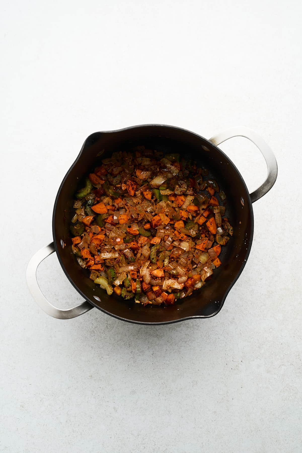 Diced vegetables and spices in a pot.