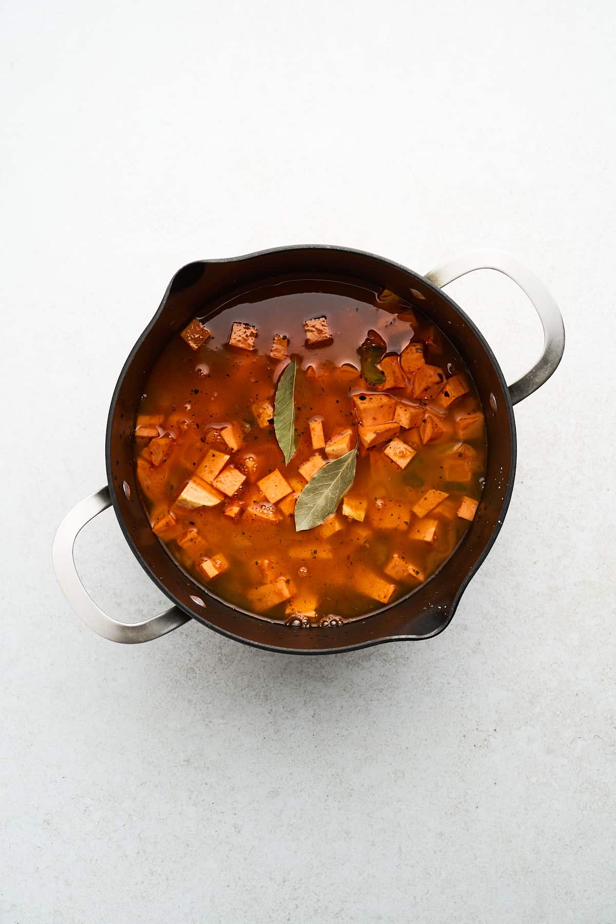 Unblended vegan sweet potato soup in a pot.