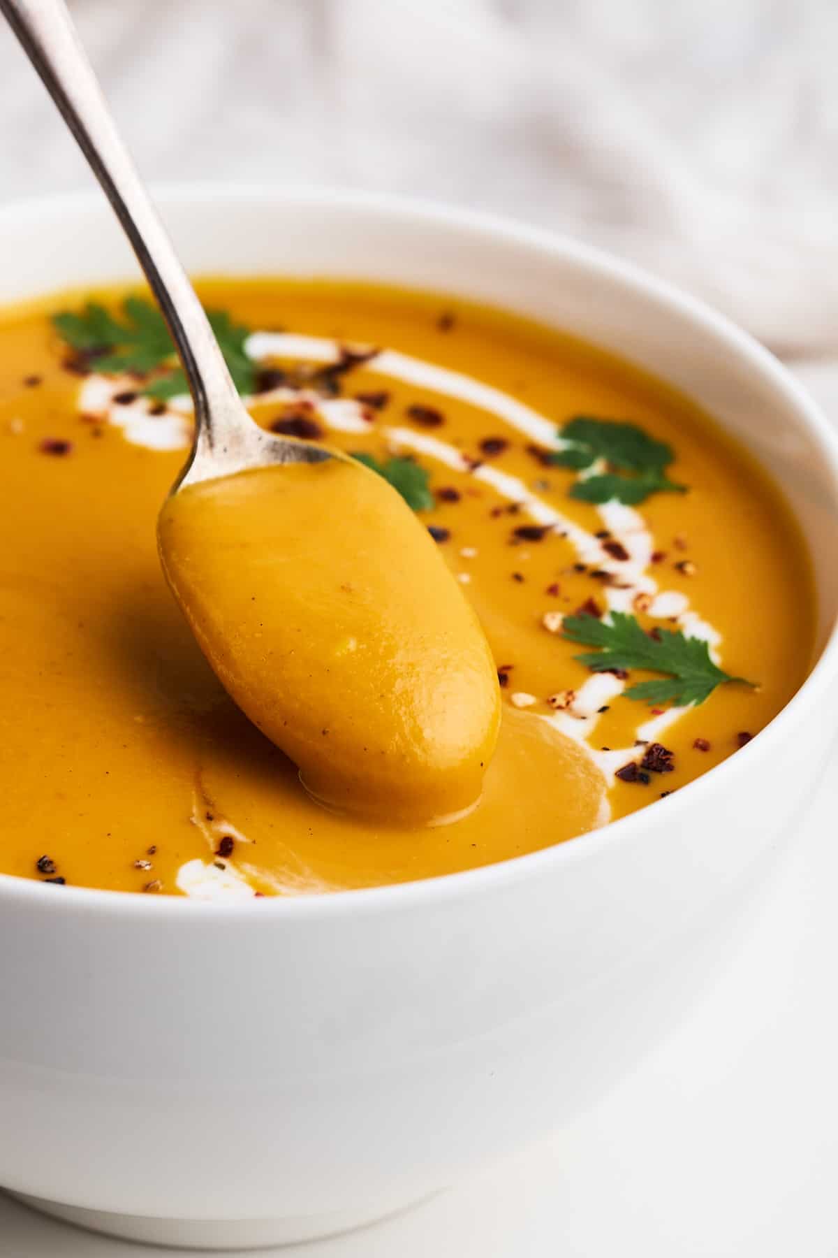 Vegan sweet potato soup on a spoon.