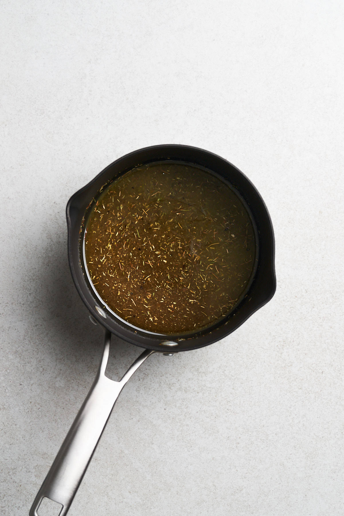 Herbed glaze in a saucepan.