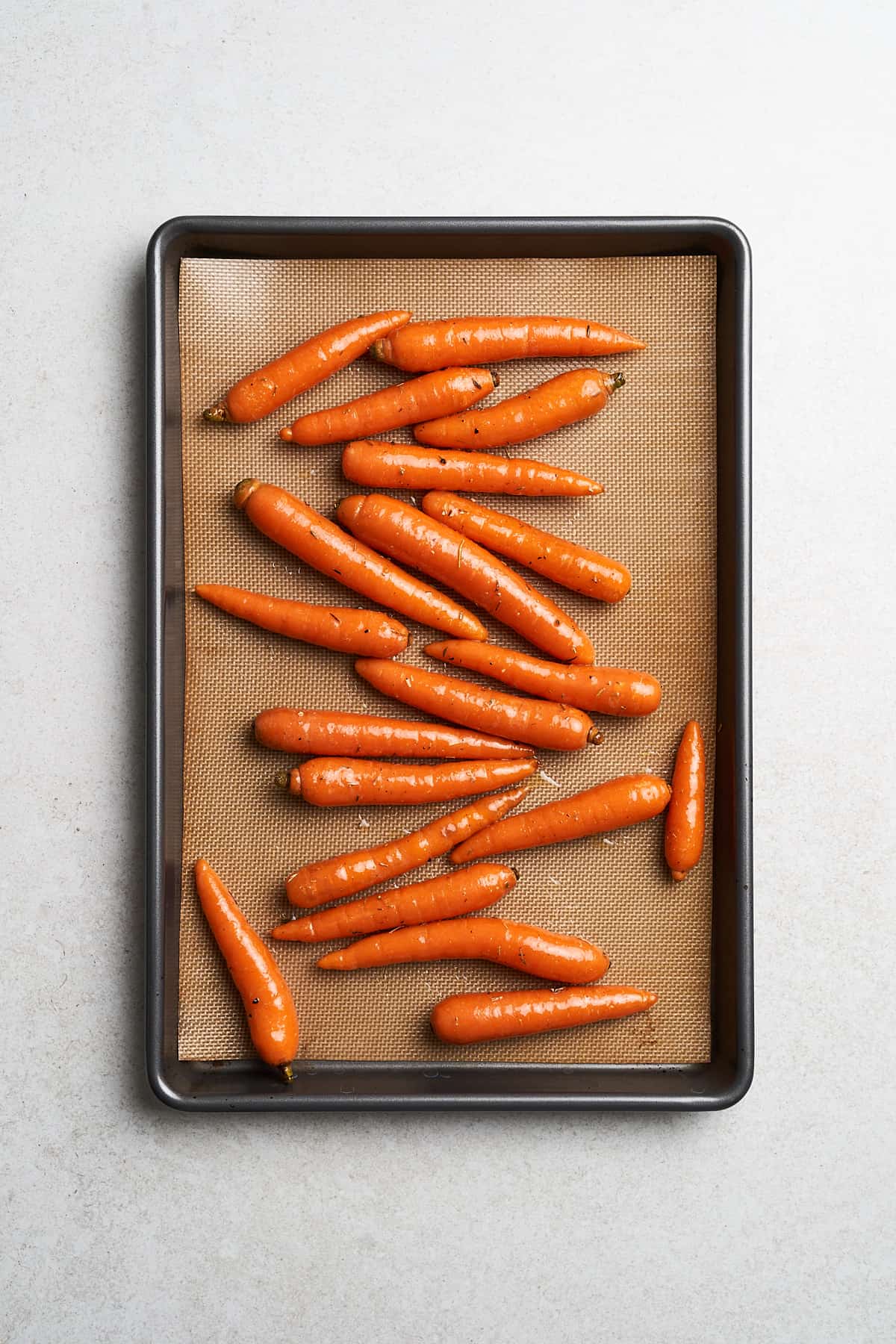 Marinated carrots on a baking sheet.