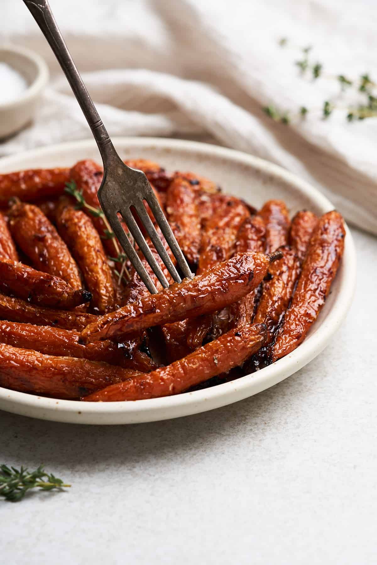 Fork holding a maple glazed carrot.