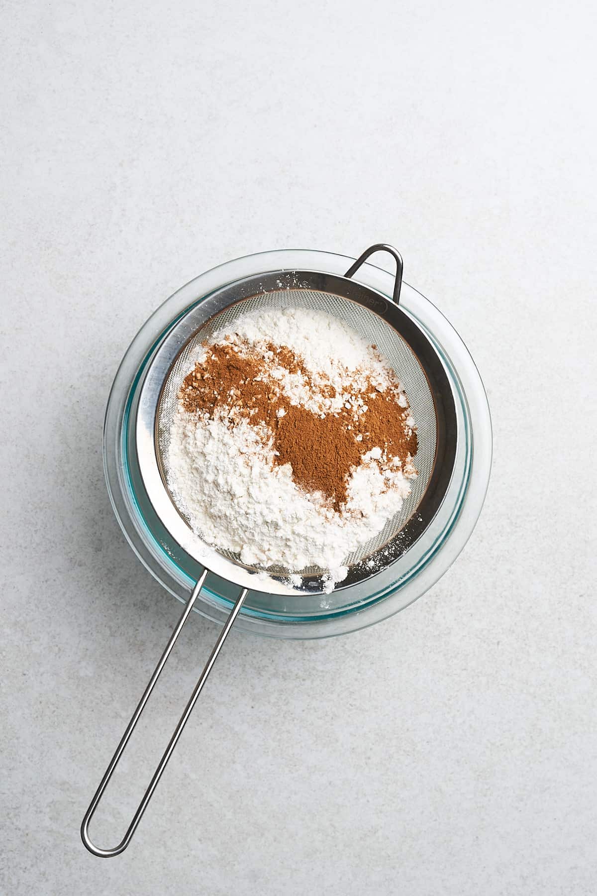 Dry ingredients for vegan apple cider donuts in a sieve.