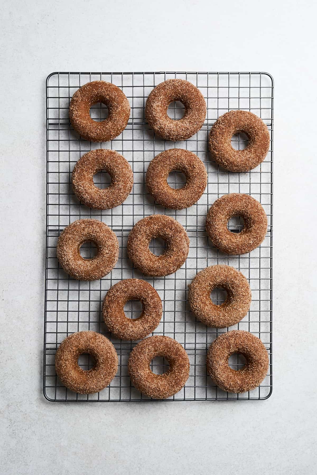 Vegan apple cider donuts on a cooling rack.