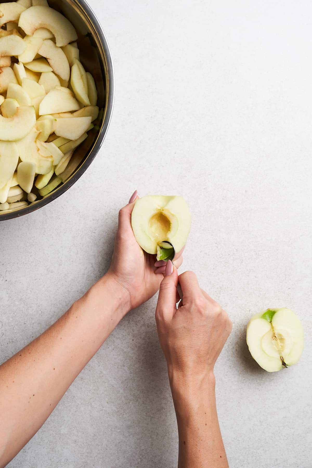Coring an apple half.