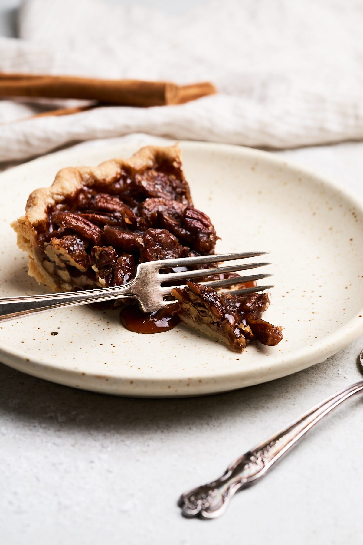 Fork biting into a slice of pecan pie.