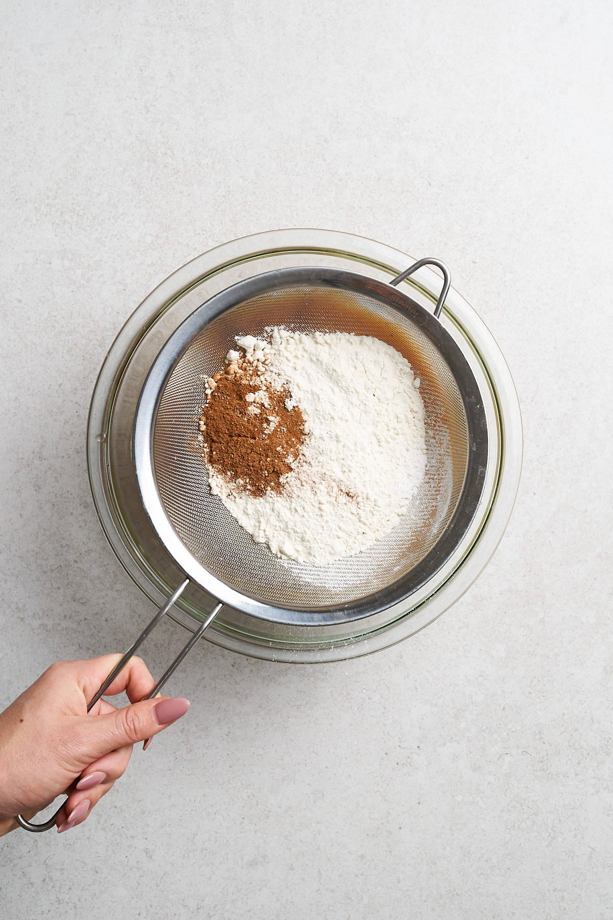 Sifting dry ingredients into a bowl.
