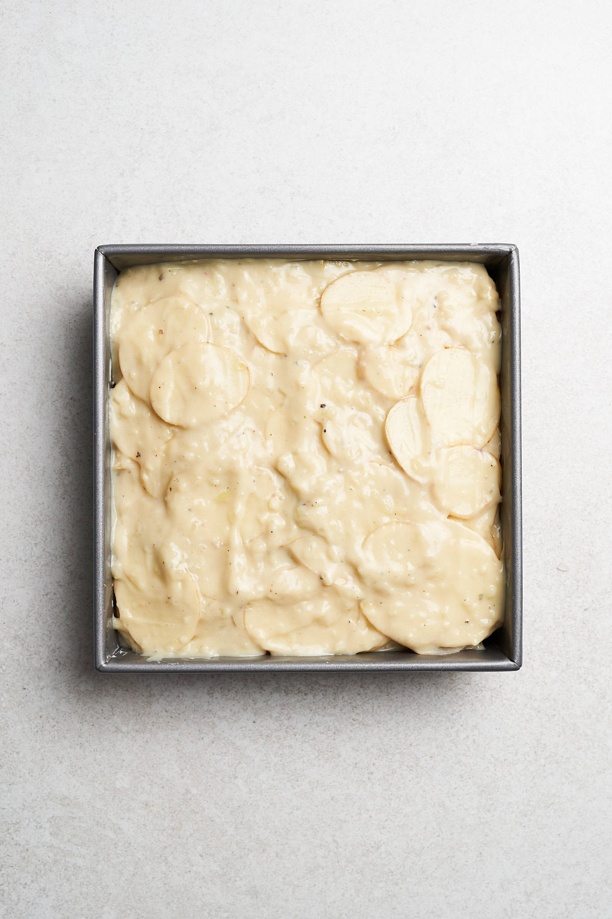 Layered potato slices and white sauce.