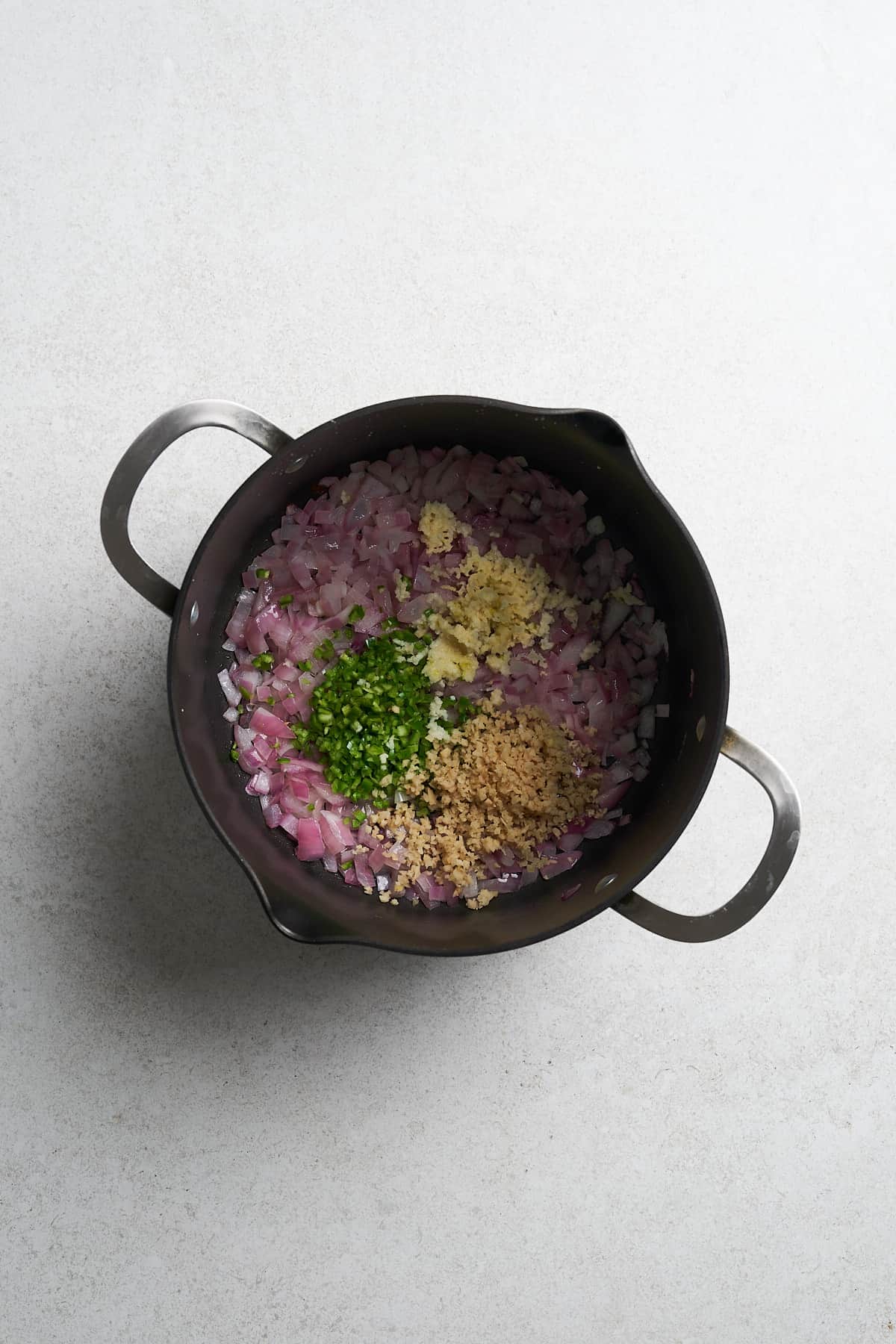 Onion, garlic, green chiles, and ginger in a saucepan.