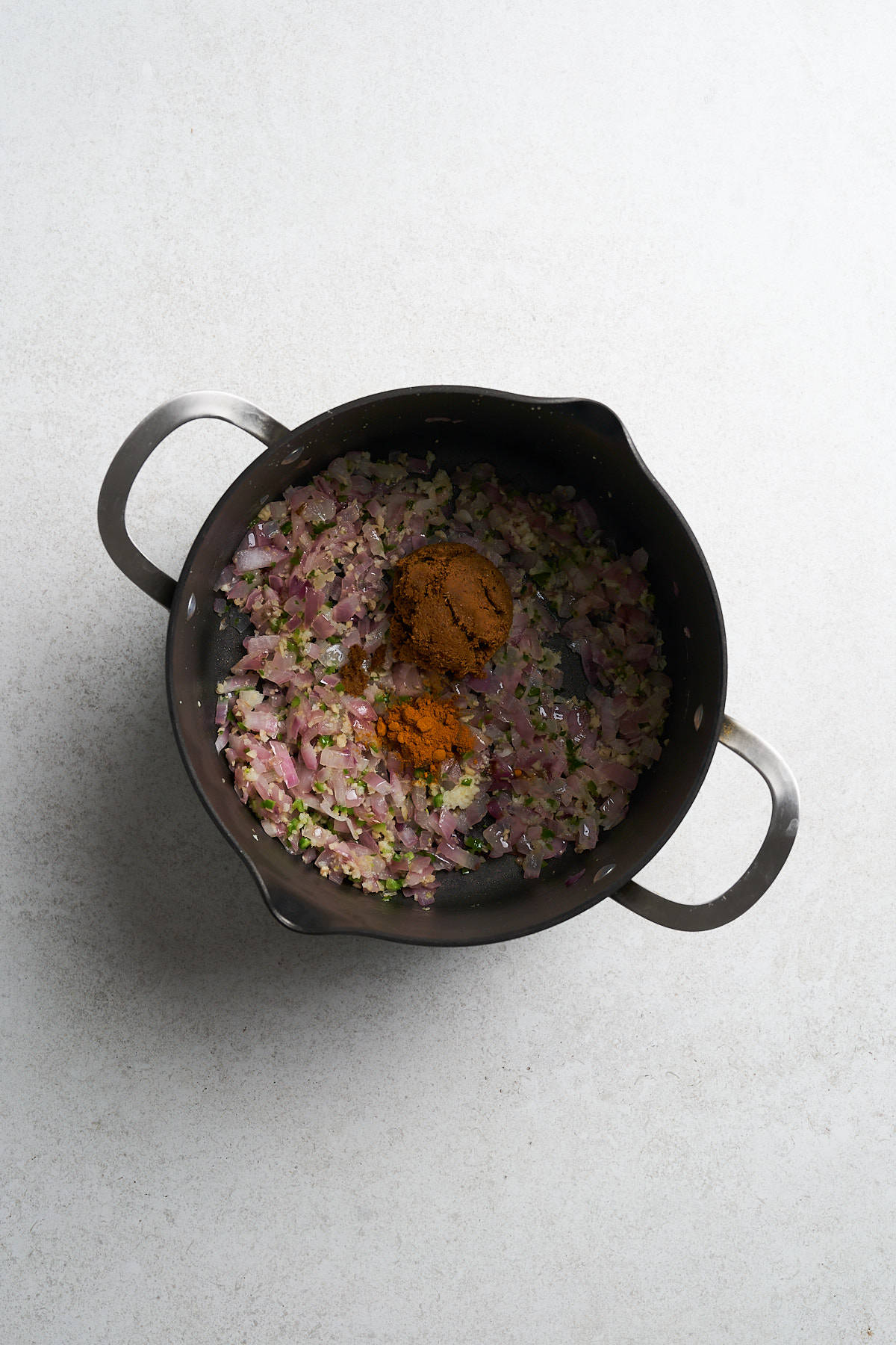 Onions with seasonings in a saucepan.