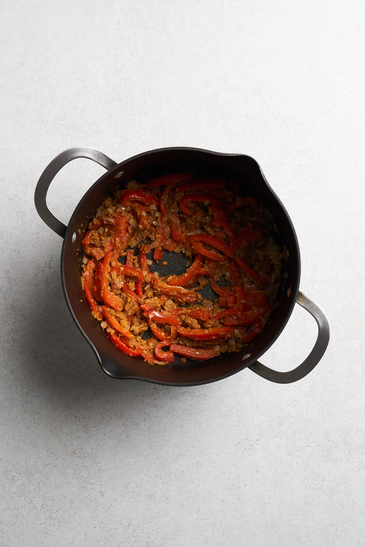 Shallots, pepper and seasonings in a pot.