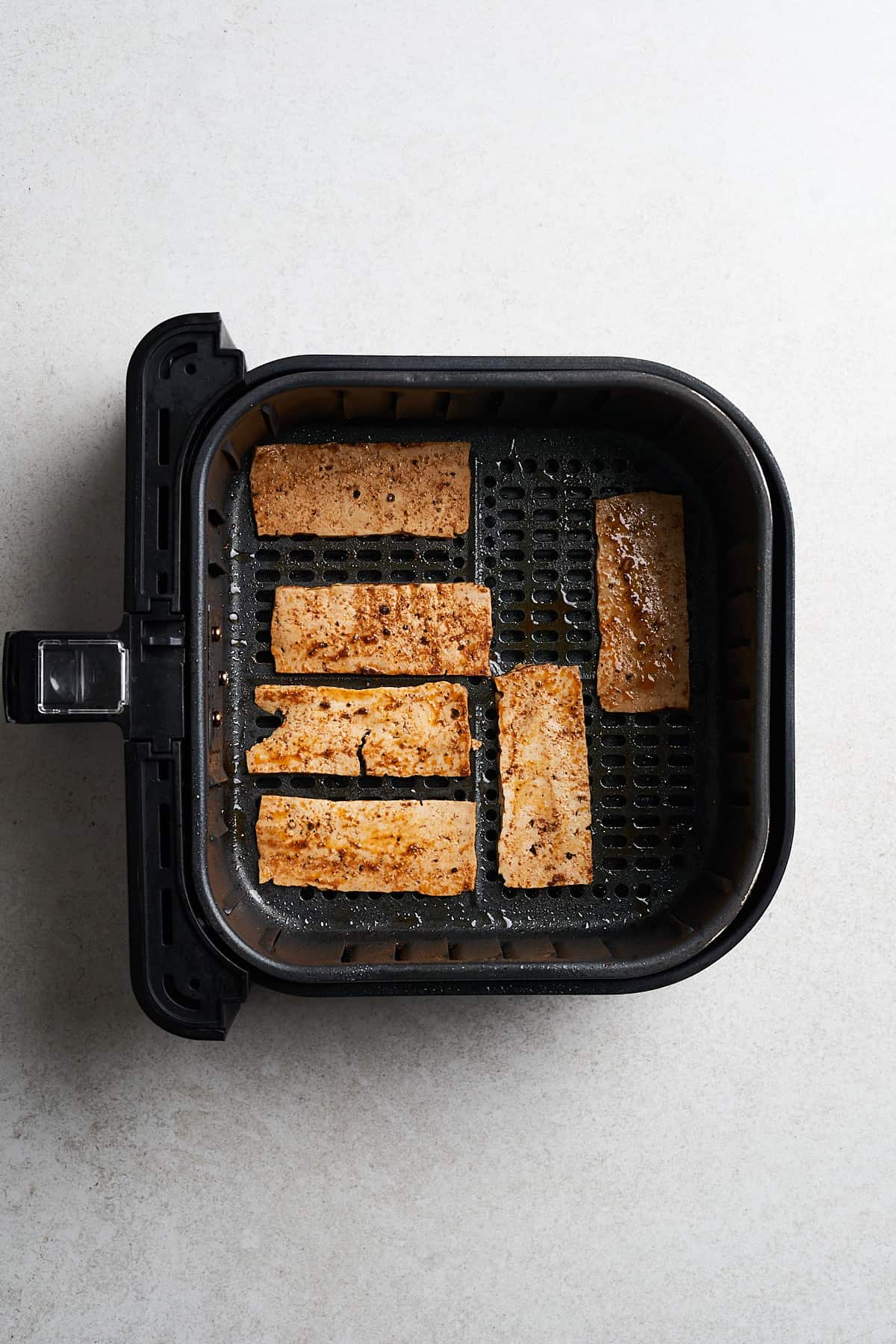 Tofu strips in an air fryer.
