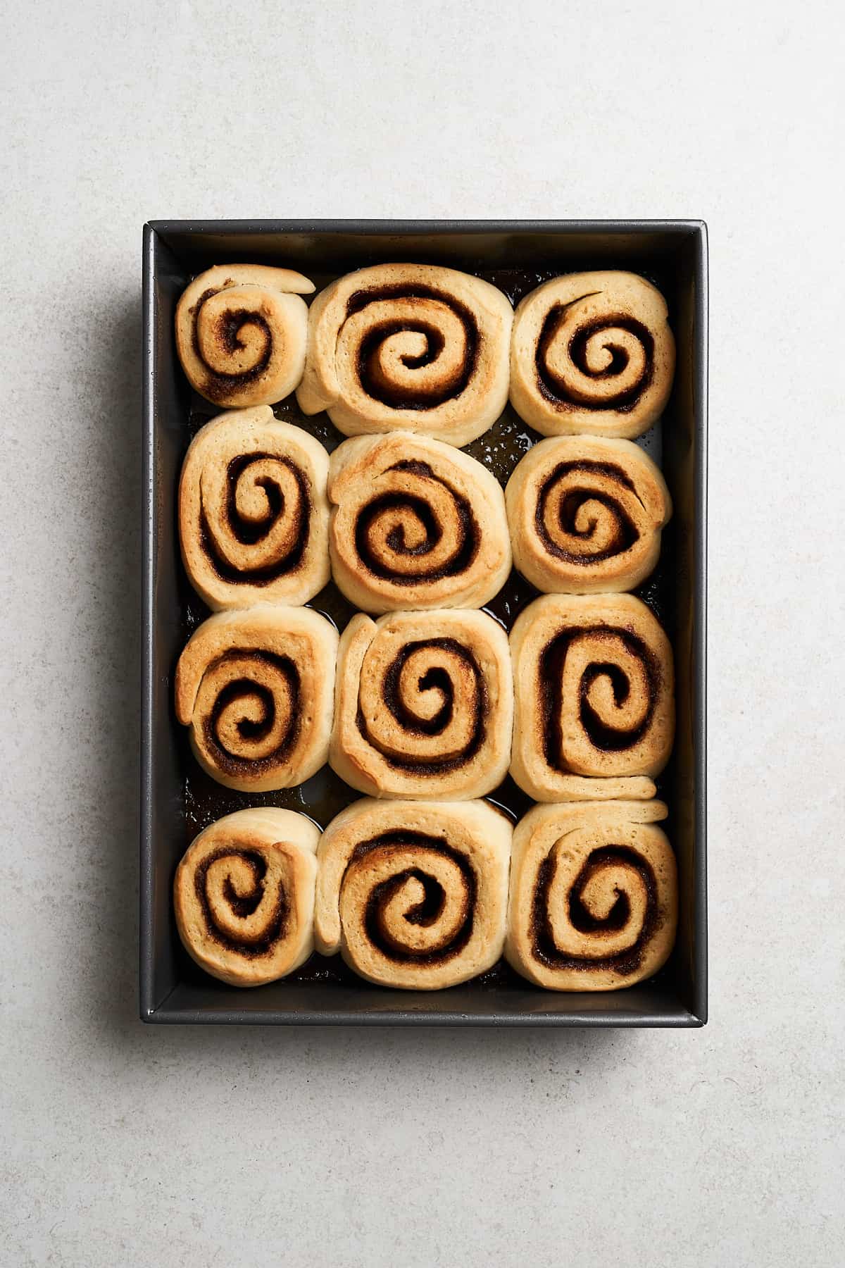 Vegan cinnamon rolls in a baking pan.