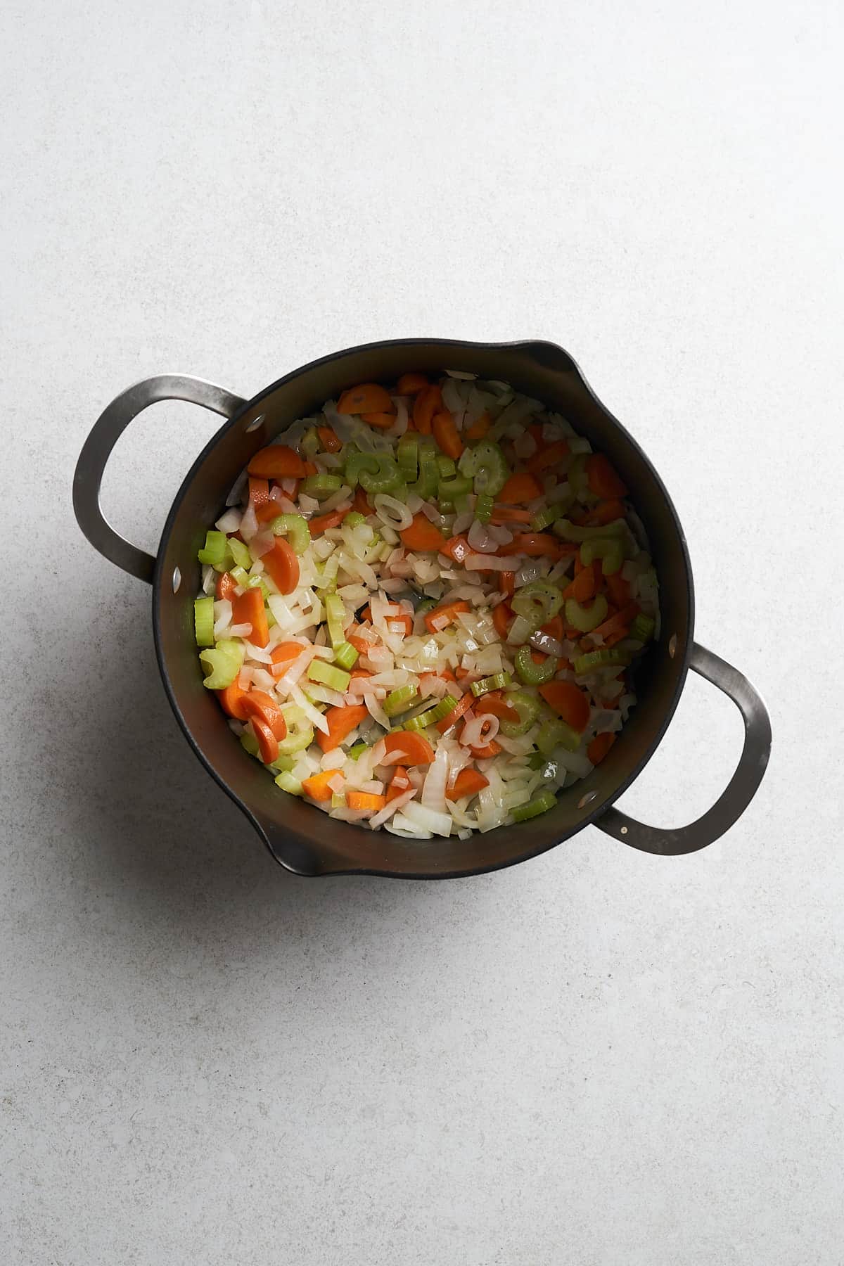 Onions, celery and carrots in a pot.