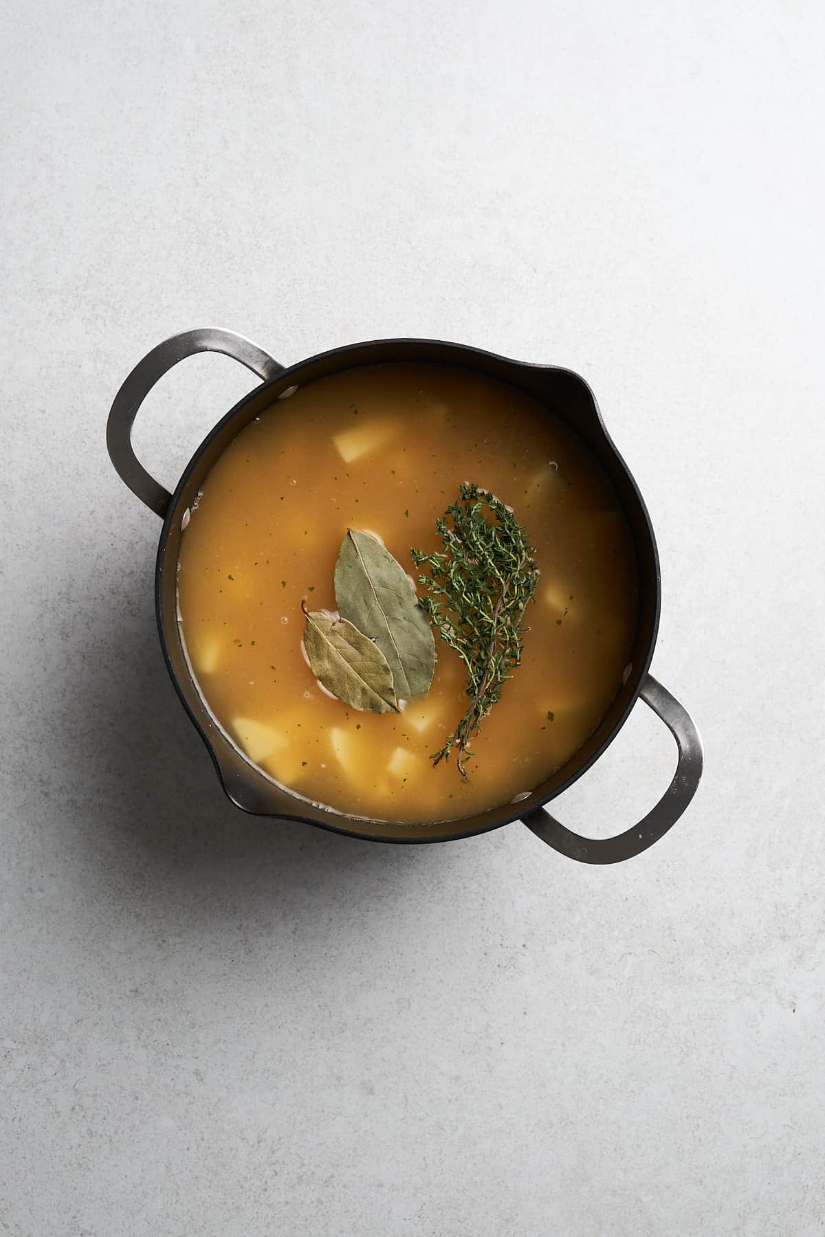 Vegan potato leek soup with vegetable broth in a pot.