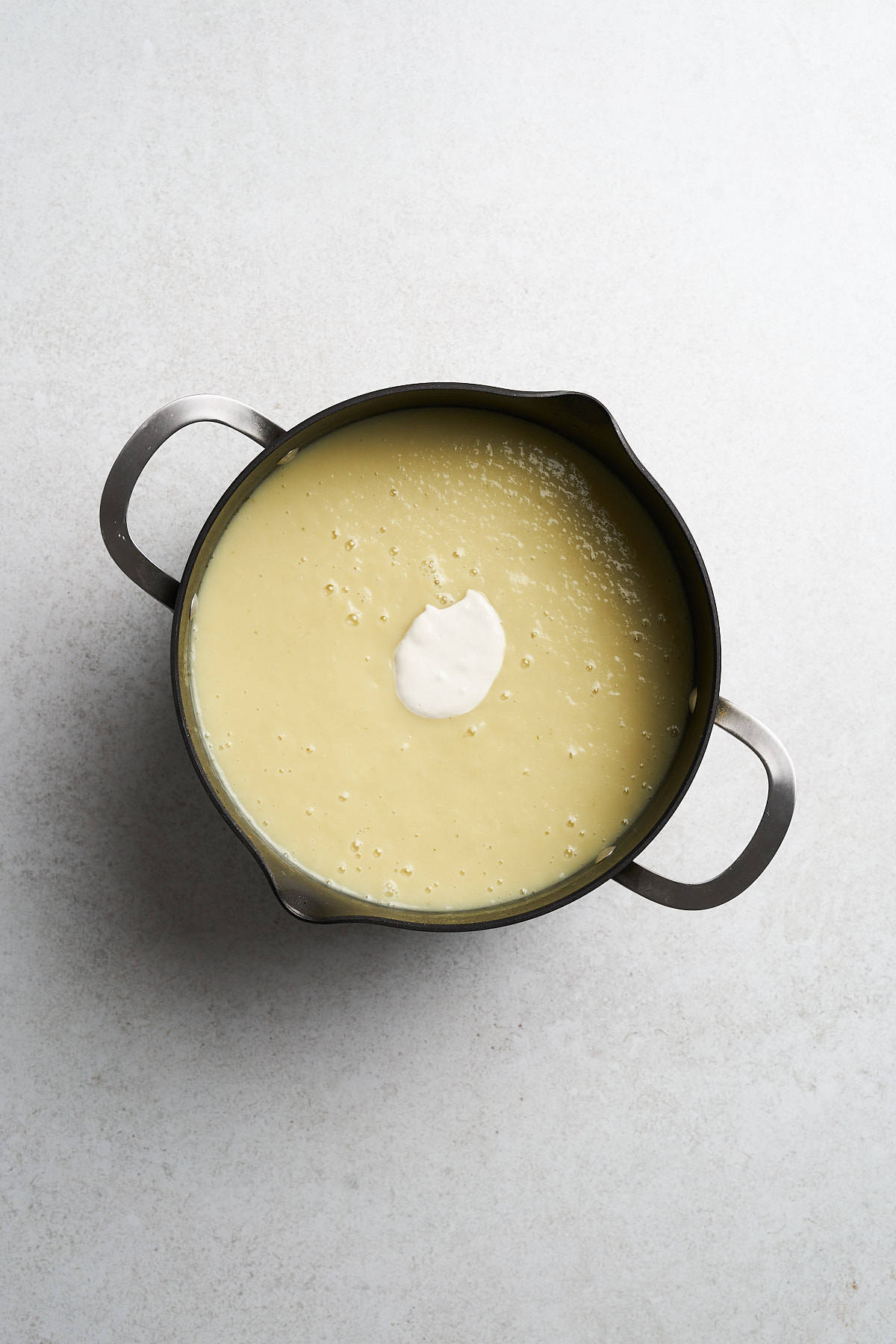 Vegan potato leek soup with cream in a pot.