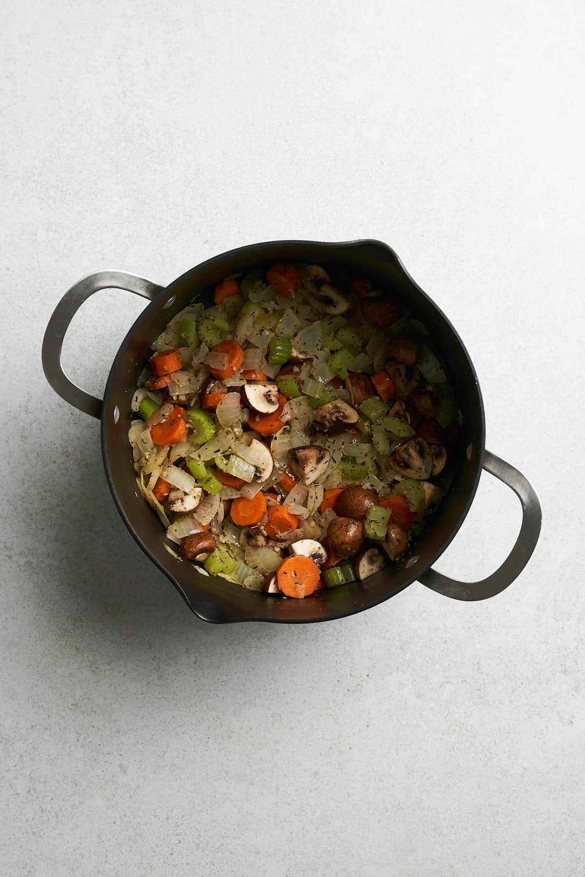 Cooked garlic, mushrooms and onions in a pot.