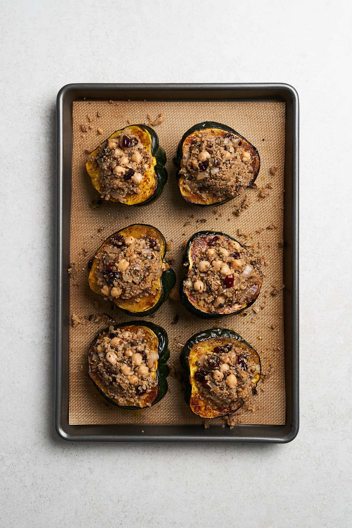 Baked acorn with prepared filling in a baking pan.
