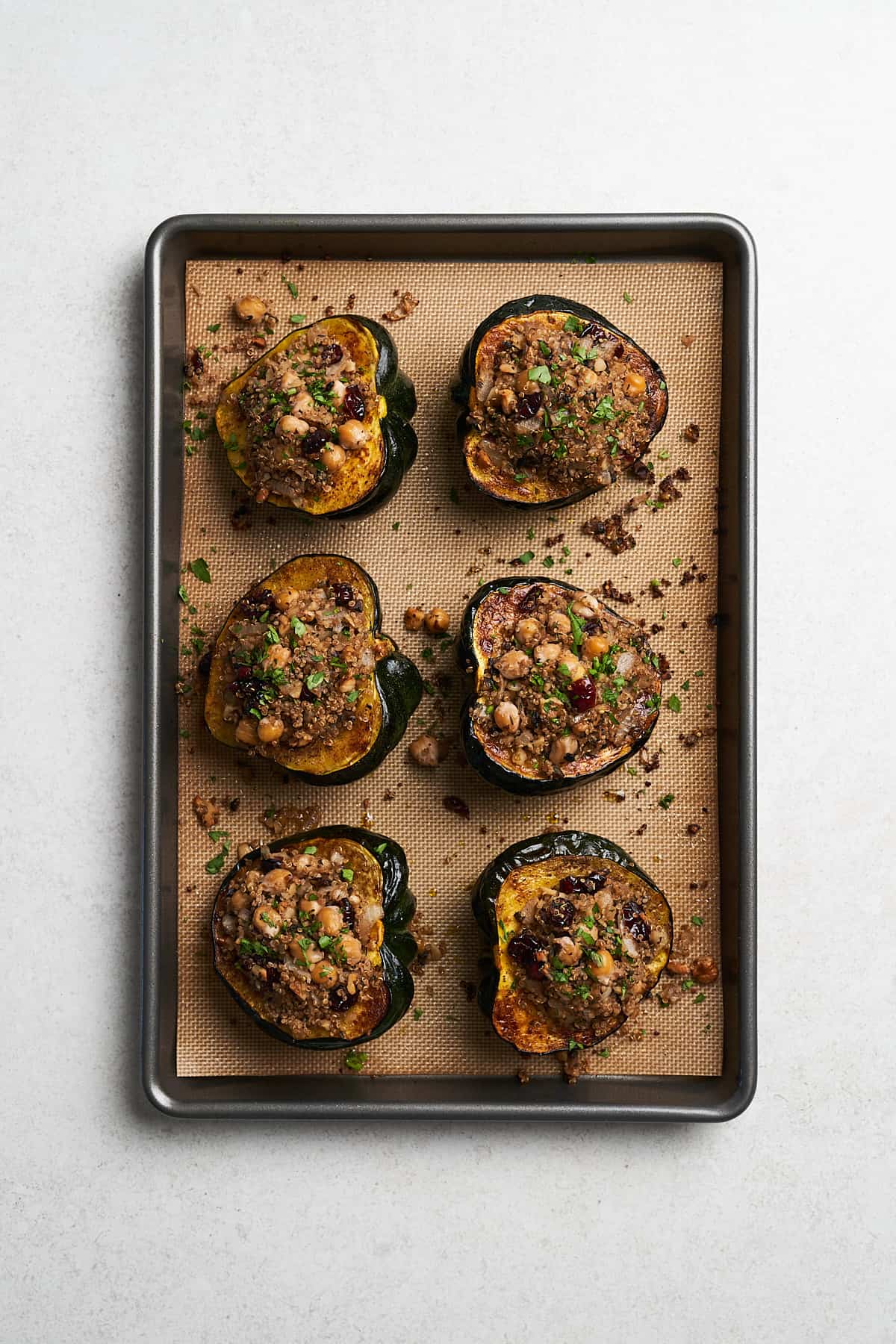Baked vegan stuffed acorn squash in a baking pan.