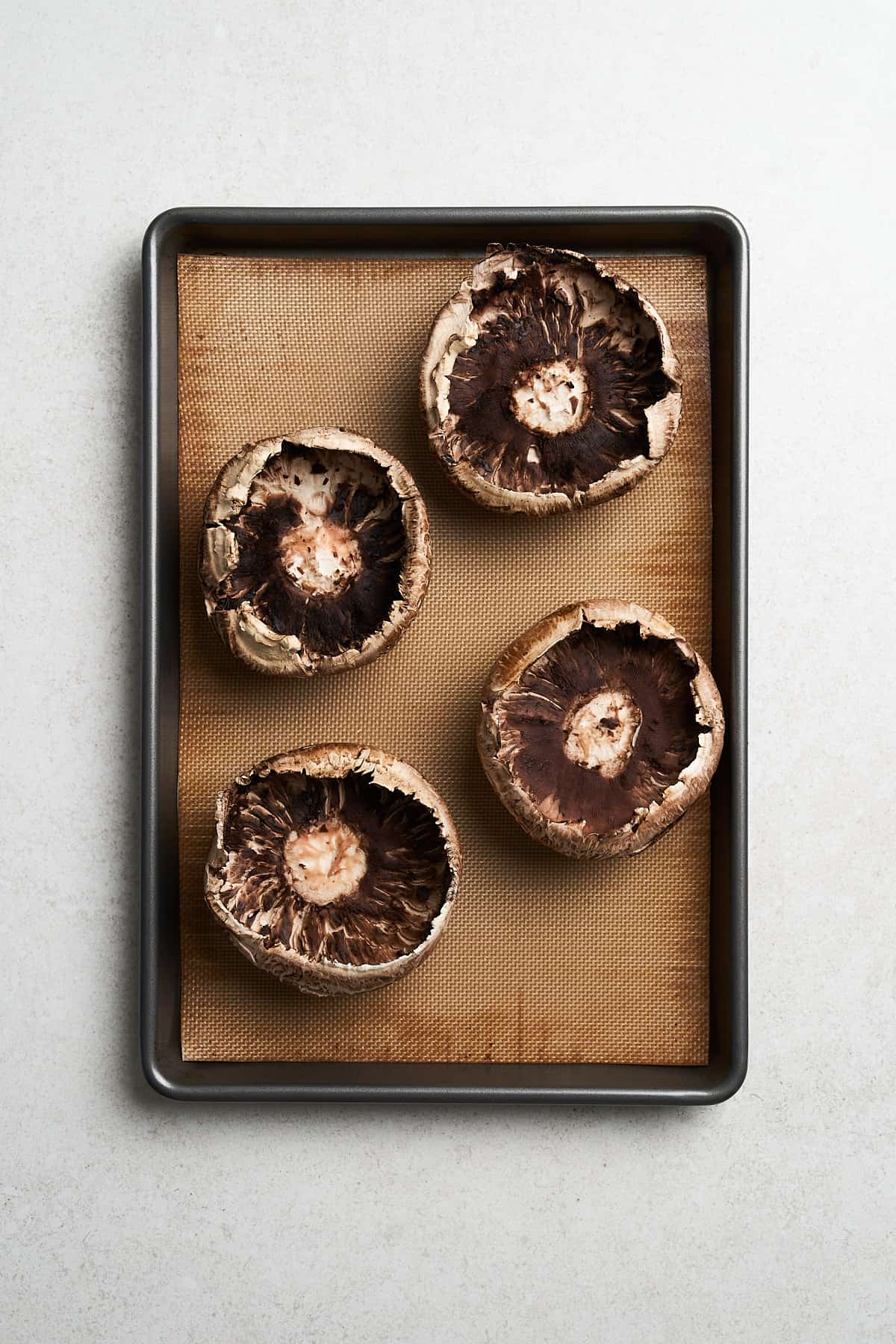 Unbaked mushrooms in a baking pan.