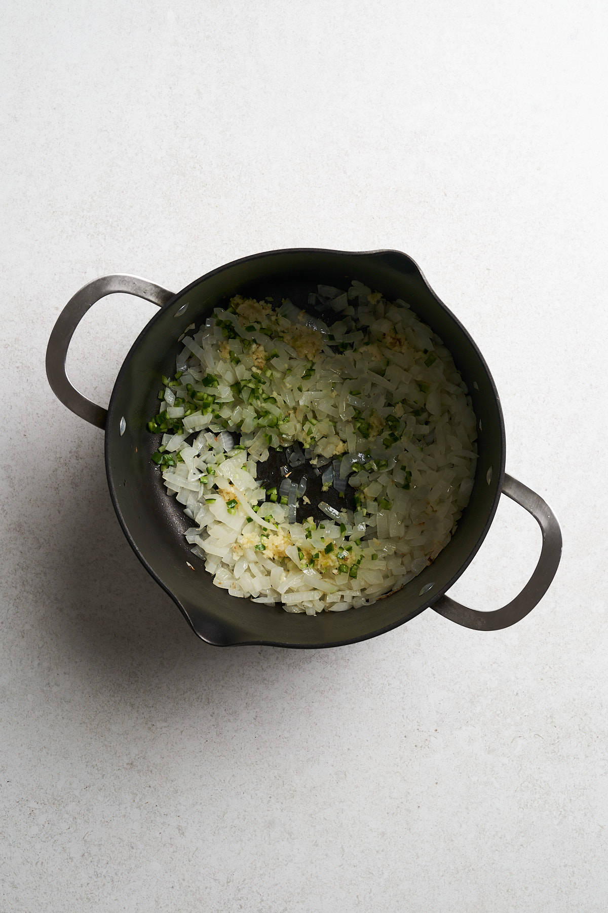 Uncooked onions, garlic and chiles in a pot.