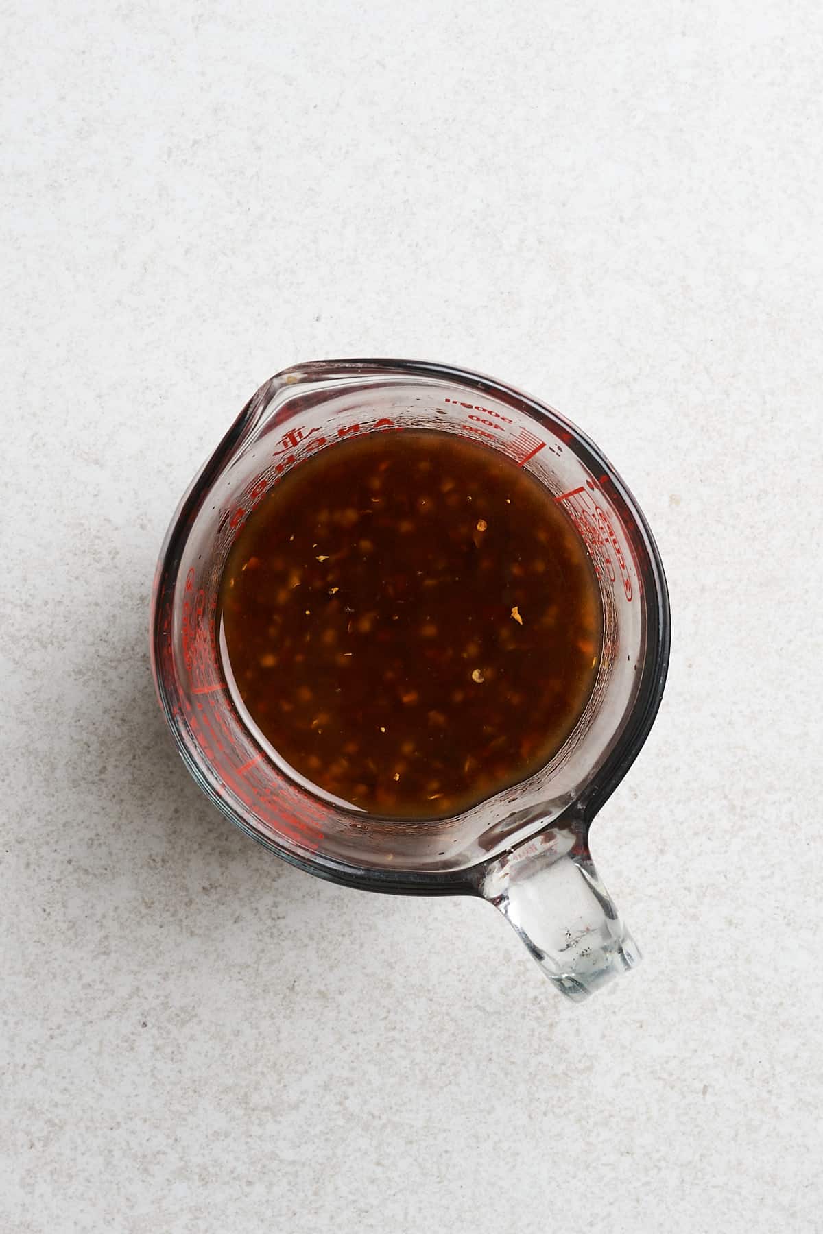 Cornstarch, red pepper flakes and other ingredients in a container.