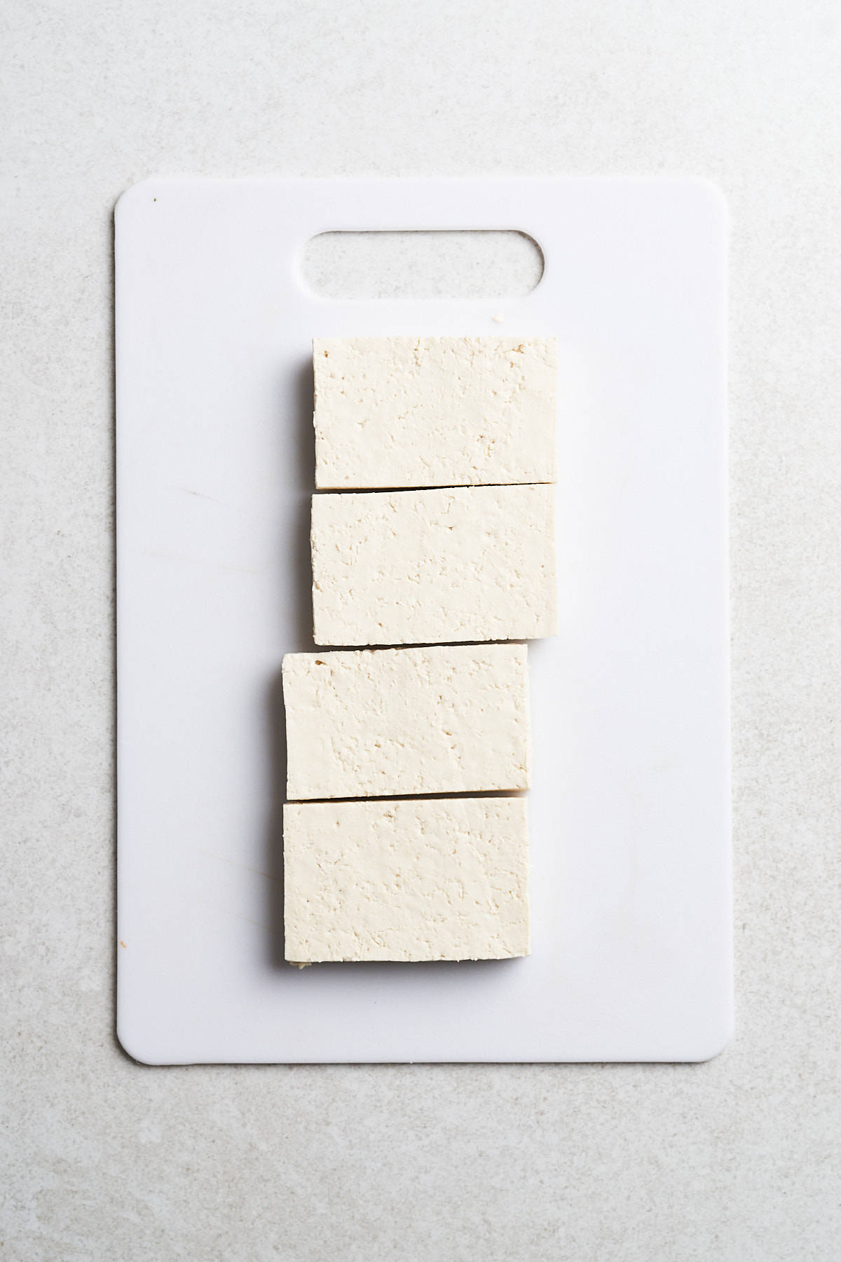 Tofu slices on a cutting board.