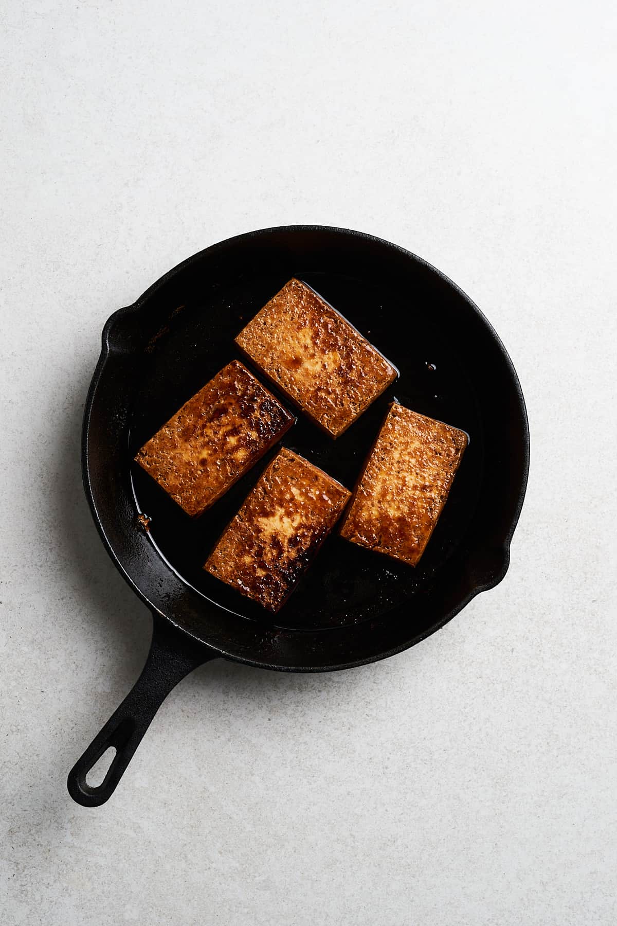 Cooked tofu slices in a frying pan.