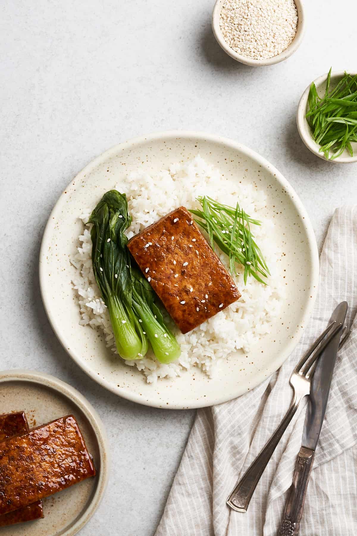 Tofu steak on a plate with vegetables.