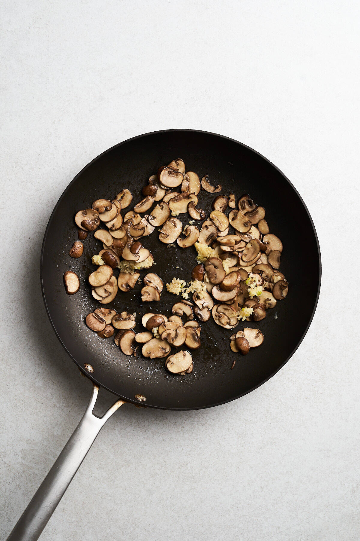 Sliced mushrooms and garlic in a skillet.