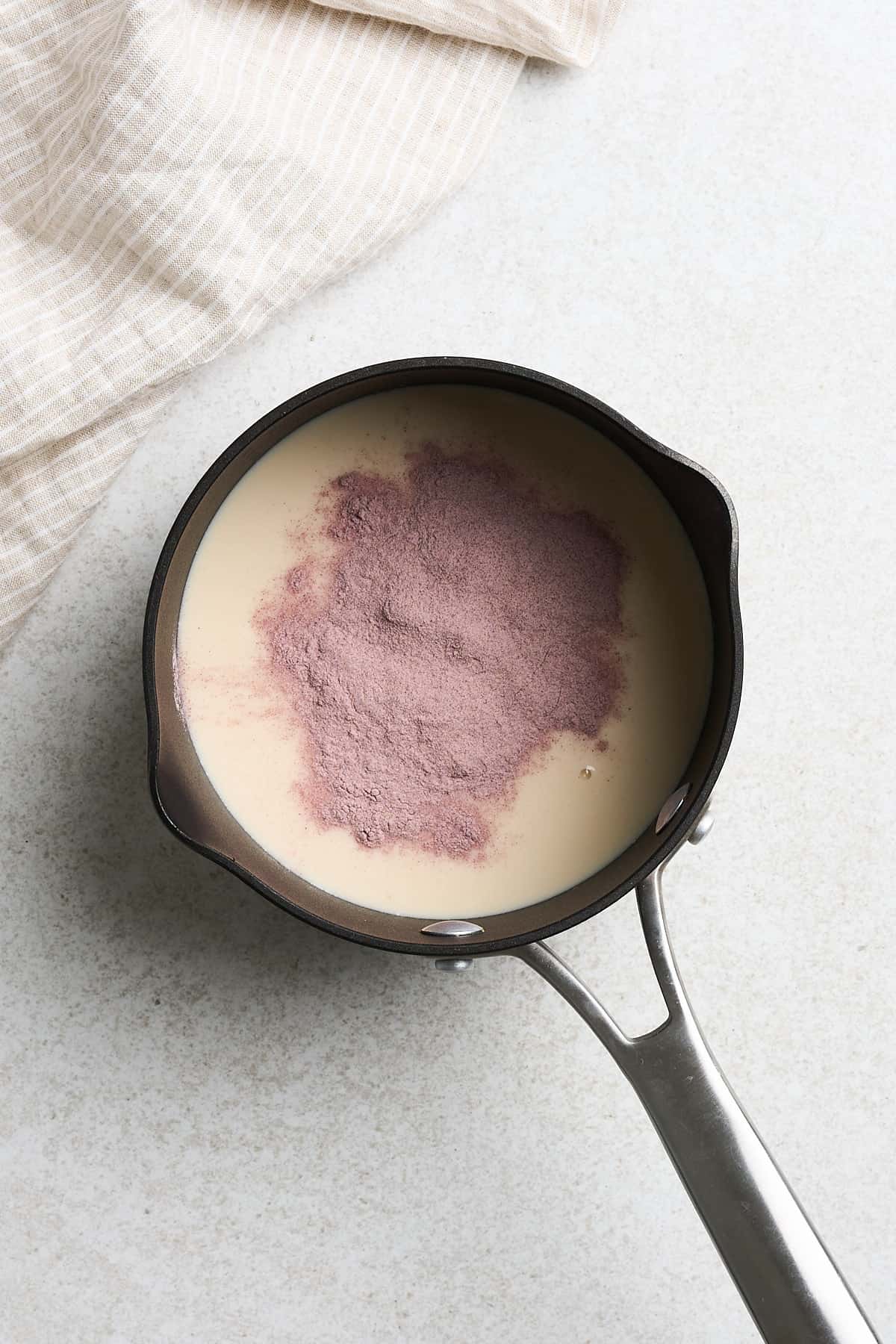 Milk, taro powder and other ingredients in a saucepan.